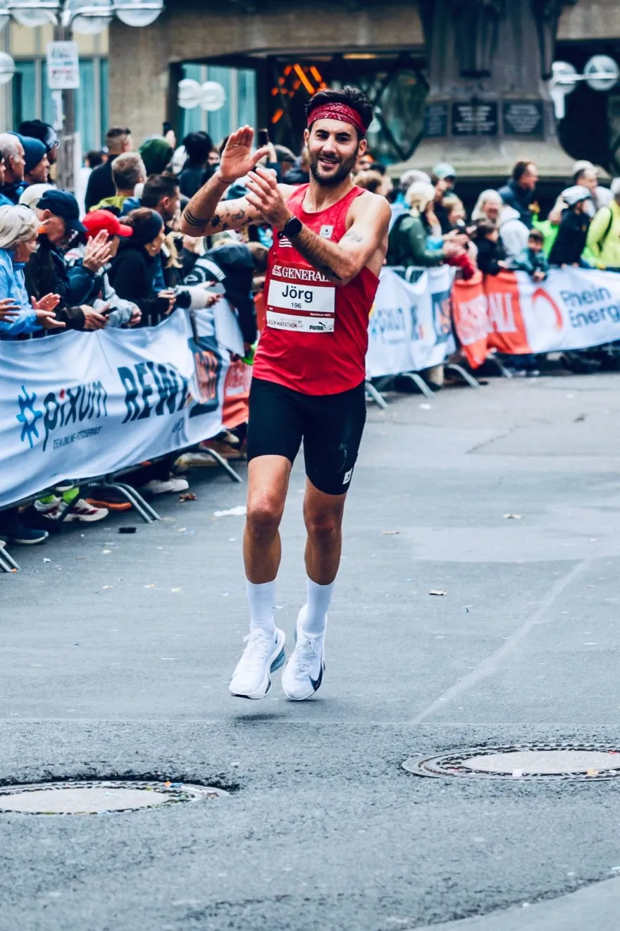 Jörg Sevenich klatscht auf der Zielgeraden des Köln-Marathons